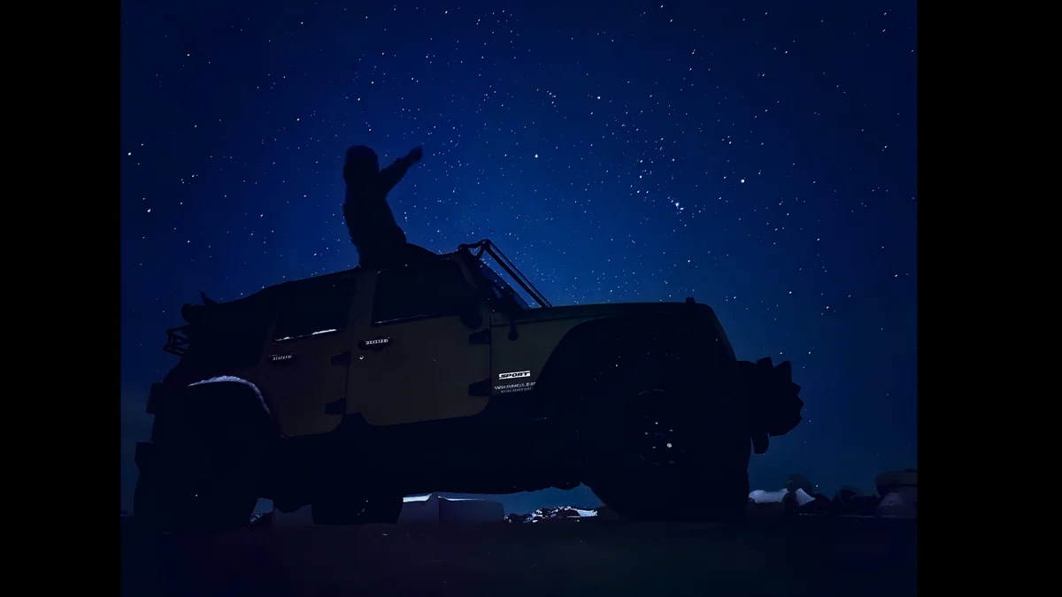 Jeep under a star-filled night sky